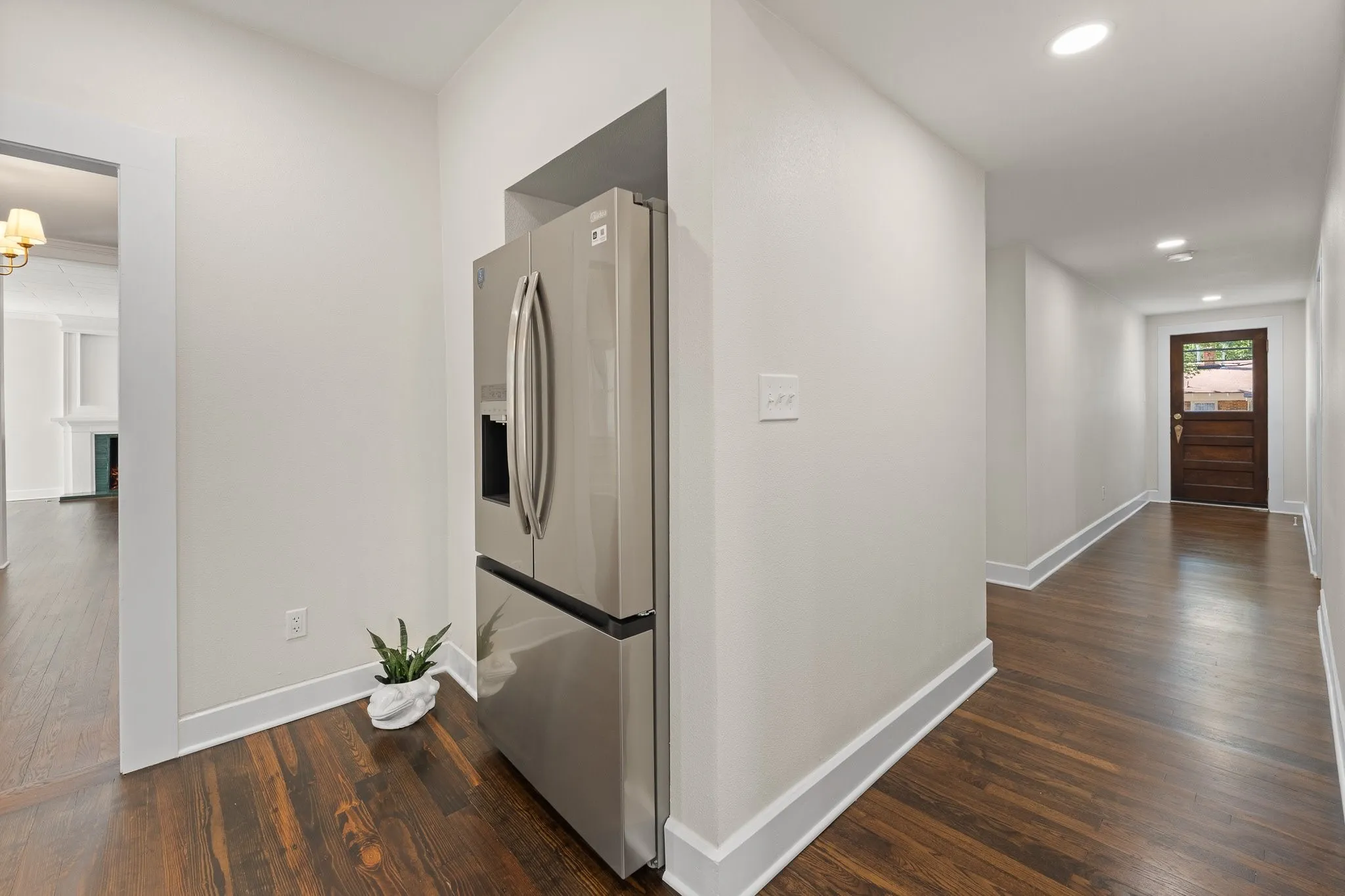 This is a hallway from the side door of the house heading to the kitchen. Did you know the brand new refrigerator comes with the house!