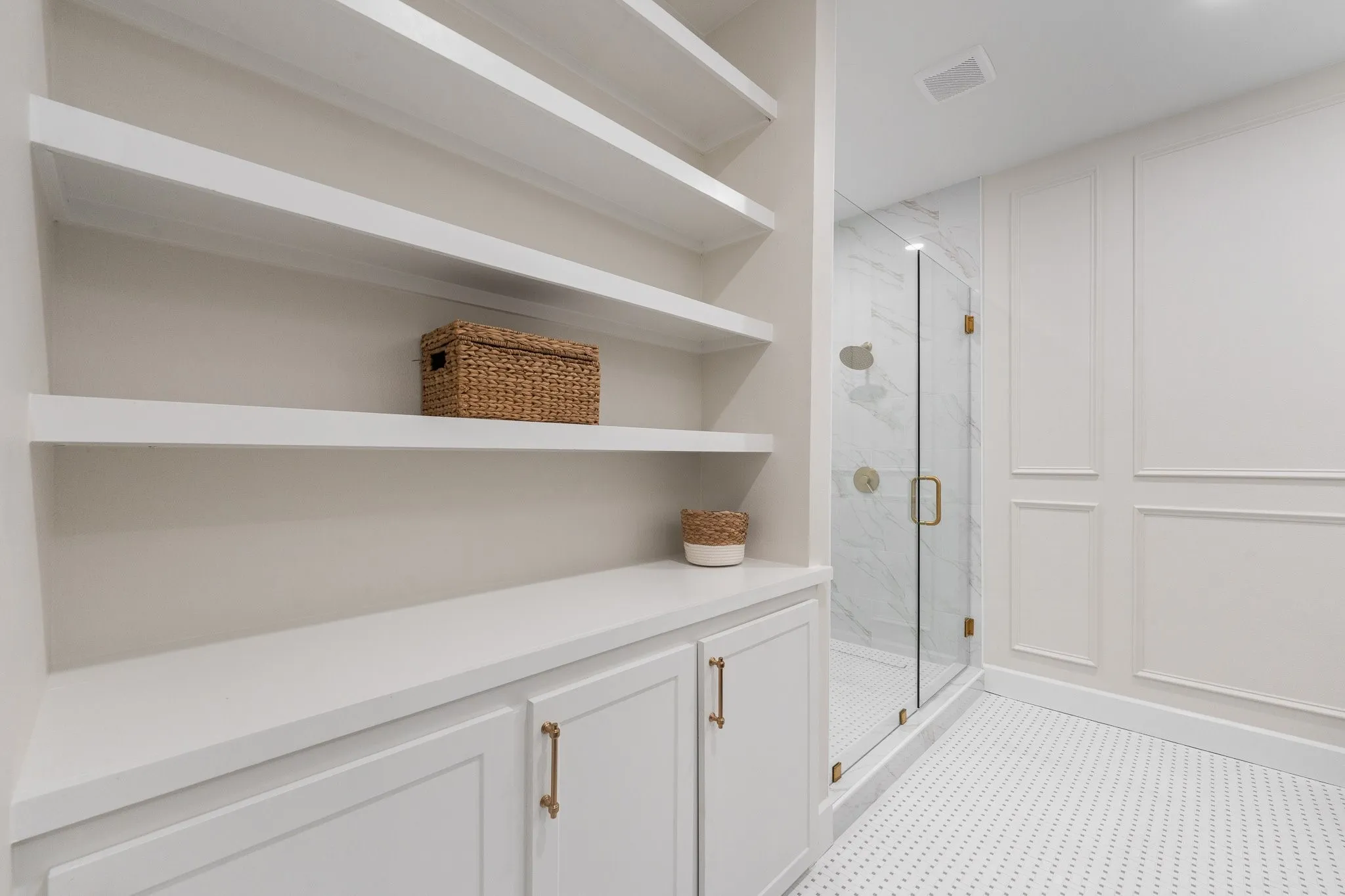 Look at all these bookshelves and cabinets in the primary bathroom.