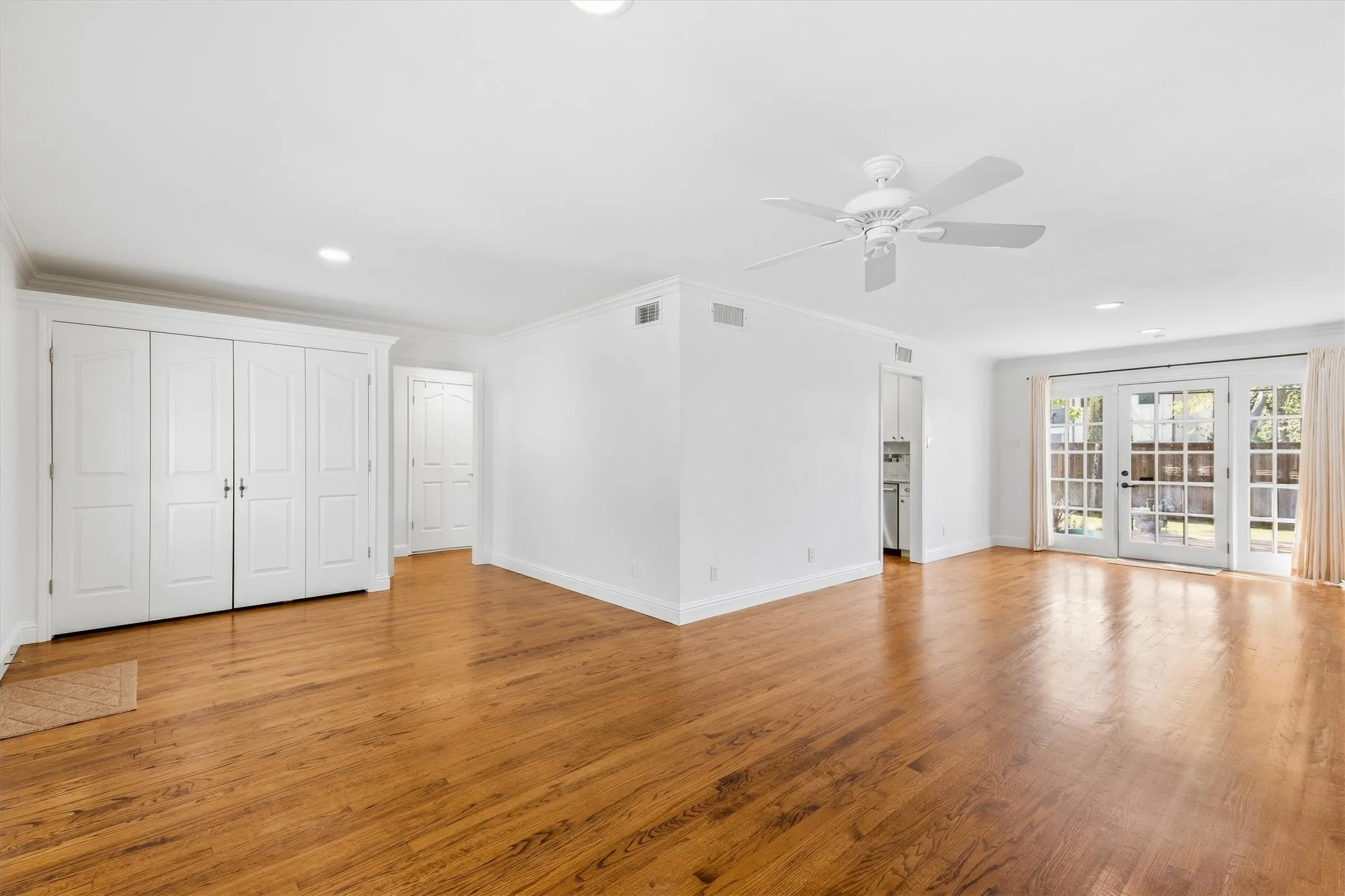 Hardwood flooring, recessed lighting, ceiling fan, and white French doors