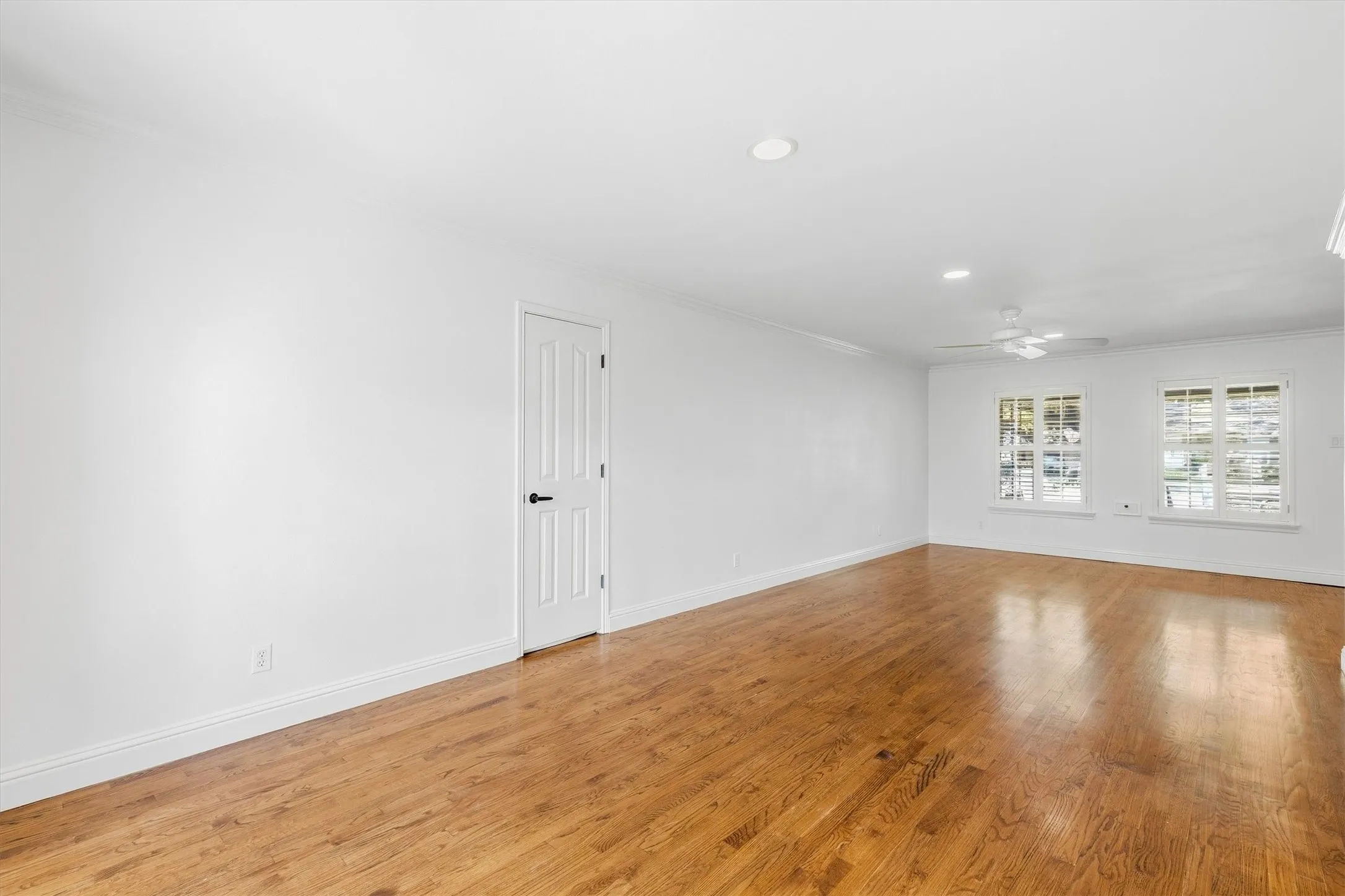Recessed lighting, wood flooring, paneled door, ceiling fan, and multiple windows