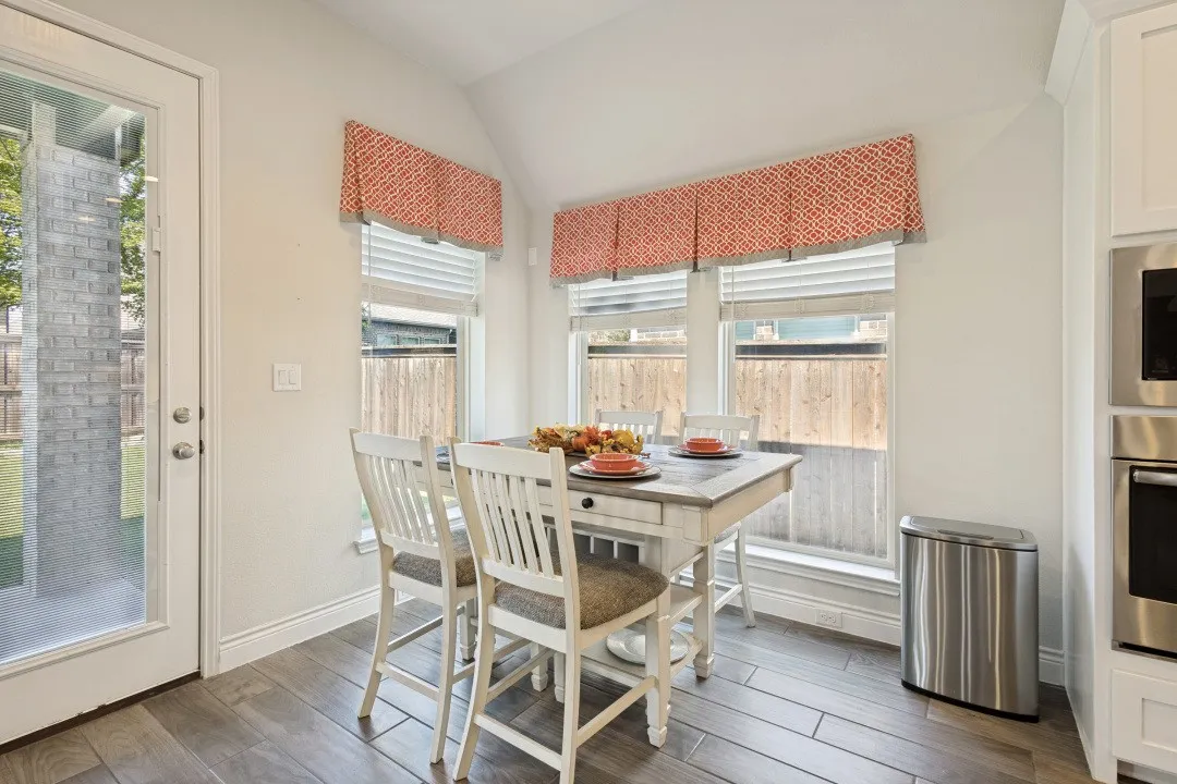 Vaulted ceiling with decorative valances, wood-finish flooring, and a full-light exterior door