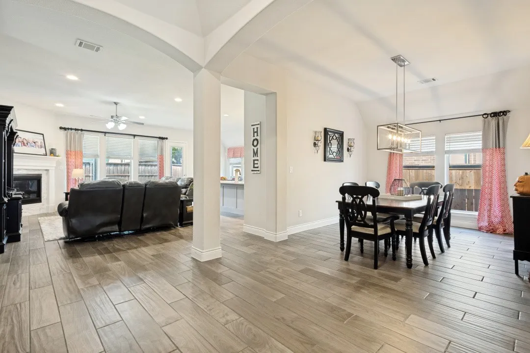 Archway entry leading to an open-concept living area with wood-finish flooring