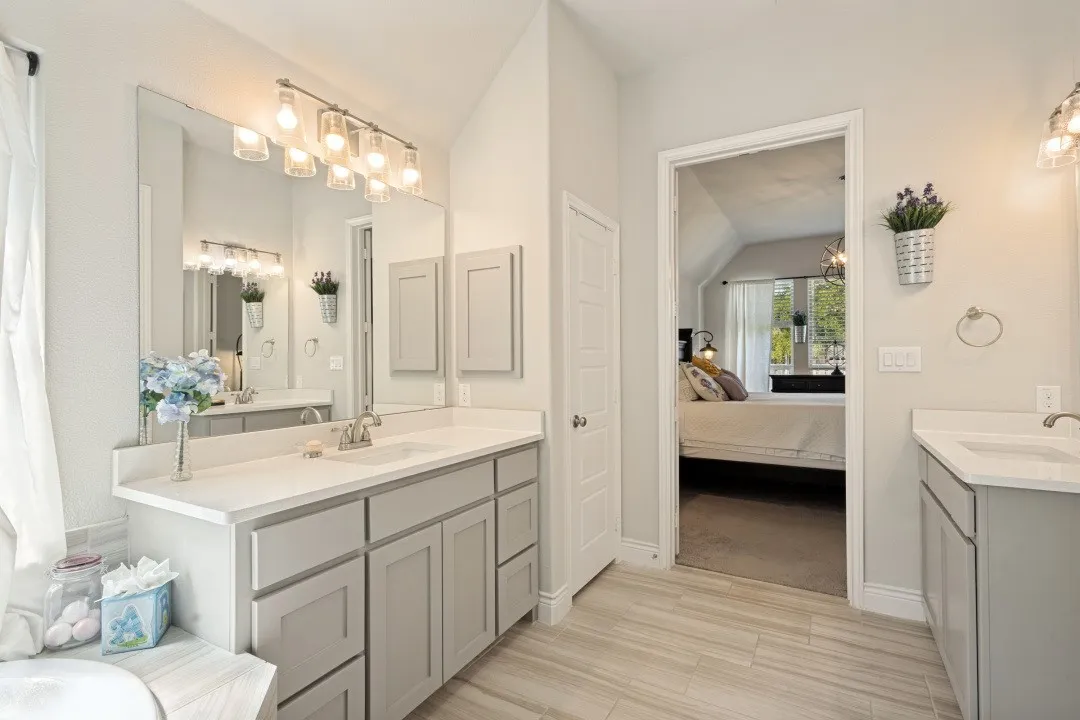 Dual vanity with individual sinks, white countertops, and light gray cabinetry