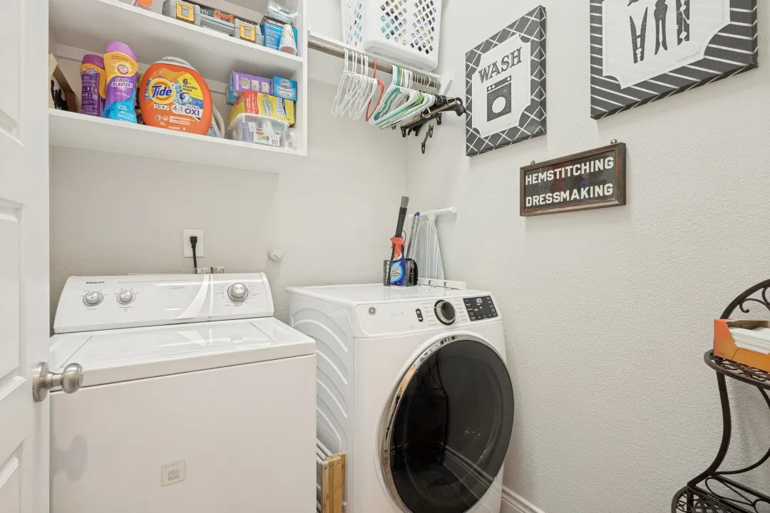 Dedicated laundry area with built-in shelving and clothes hanging rod