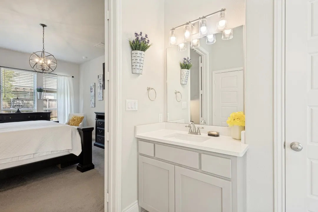 Vanity with light gray shaker cabinetry, white countertop, and single basin sink