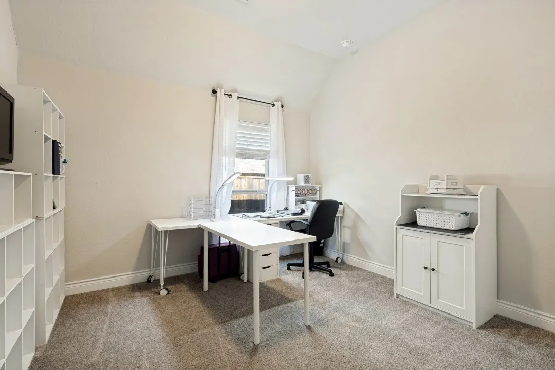 Carpeted room with a vaulted ceiling and a window featuring blinds and drapes