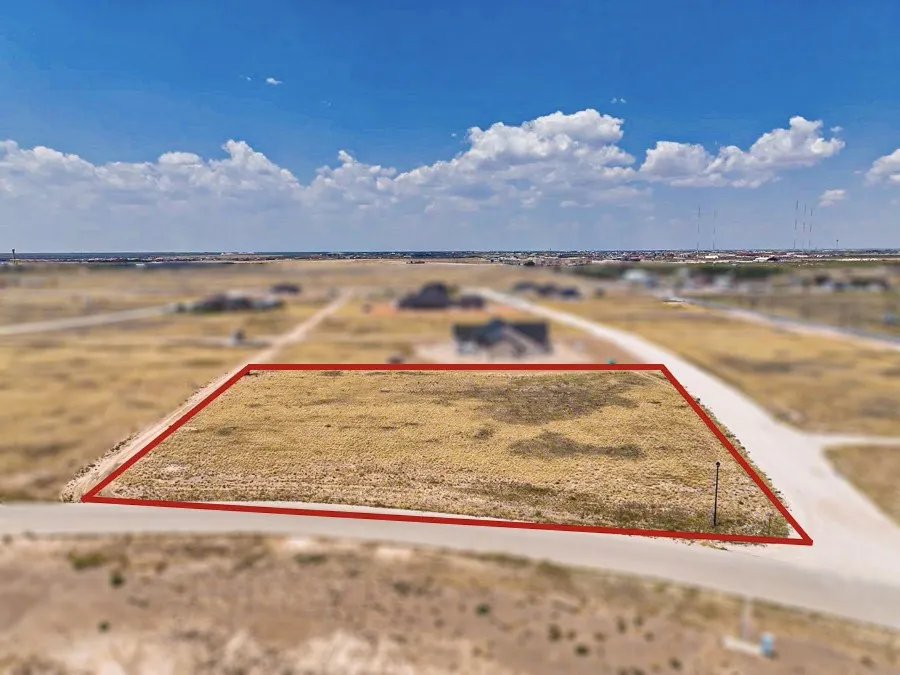 Expansive undeveloped lot with open terrain and a clear sky backdrop