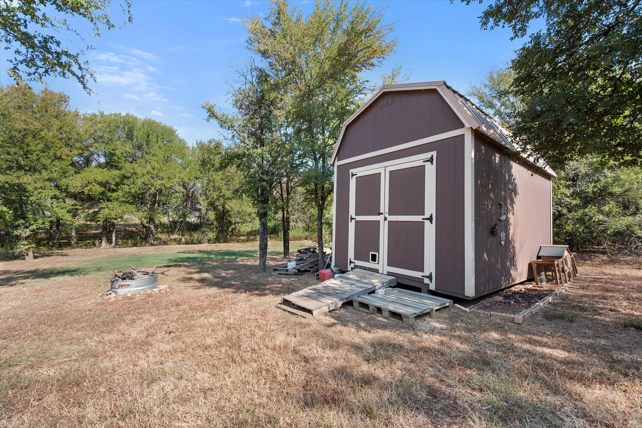 Barn-style shed with double doors and a wood ramp