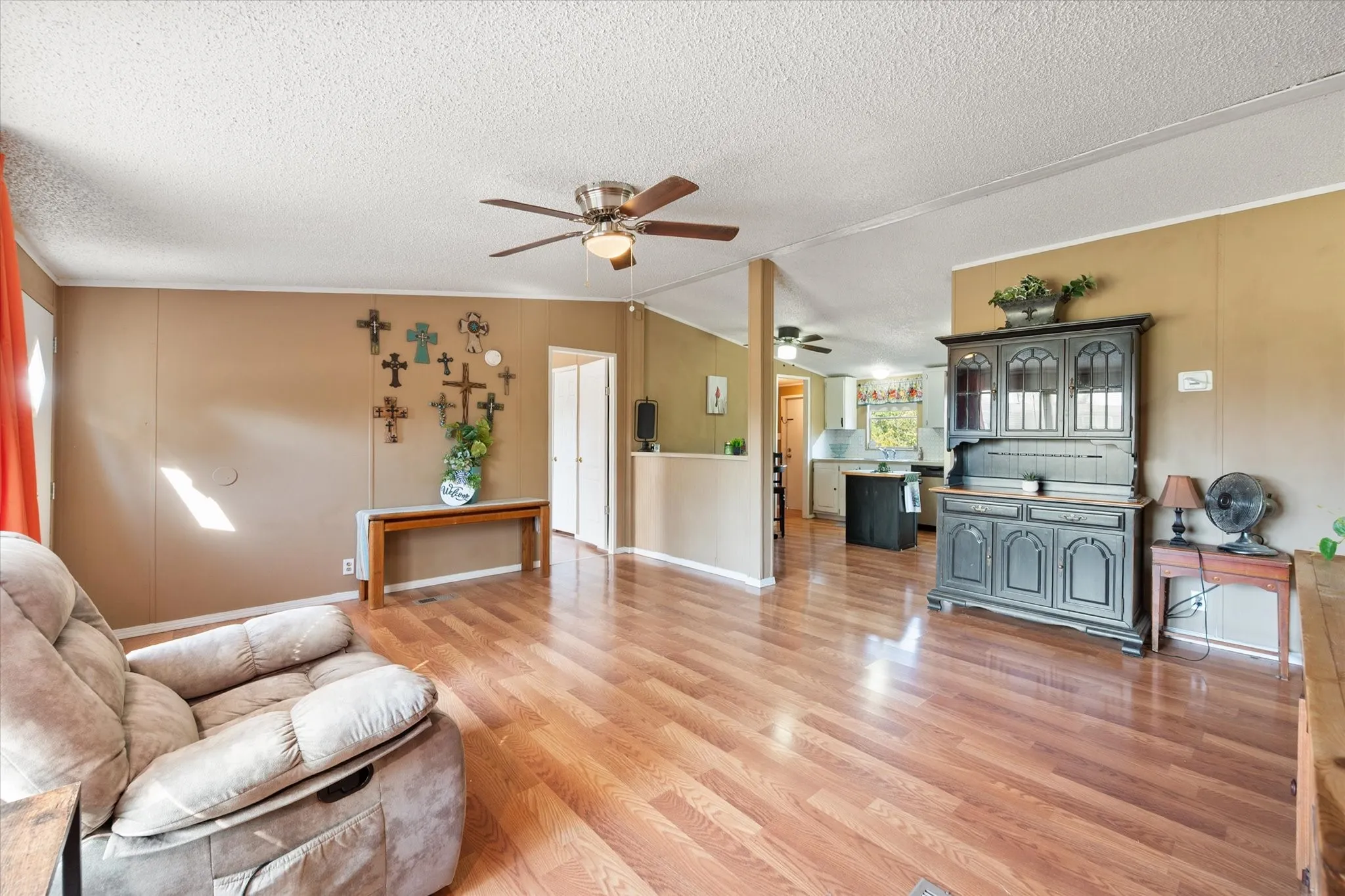 Open concept living area featuring wood-finish flooring, a ceiling fan, and painted walls