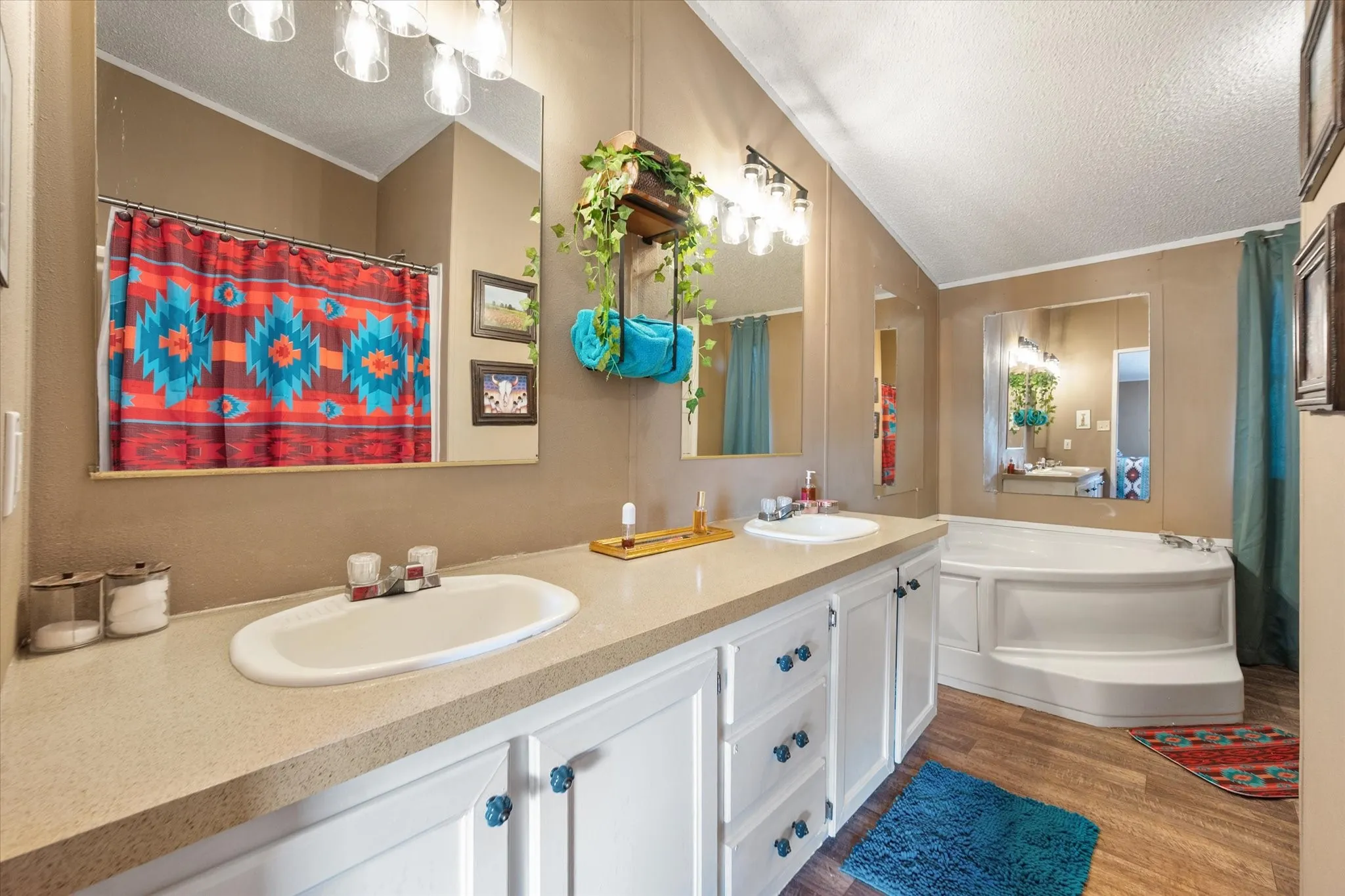 Dual vanity with integrated sinks, ample counter space, white cabinetry, and wood-finish​​‌​​​​‌​​‌‌​‌‌​​​‌‌​‌​‌​‌​​​‌​​ flooring