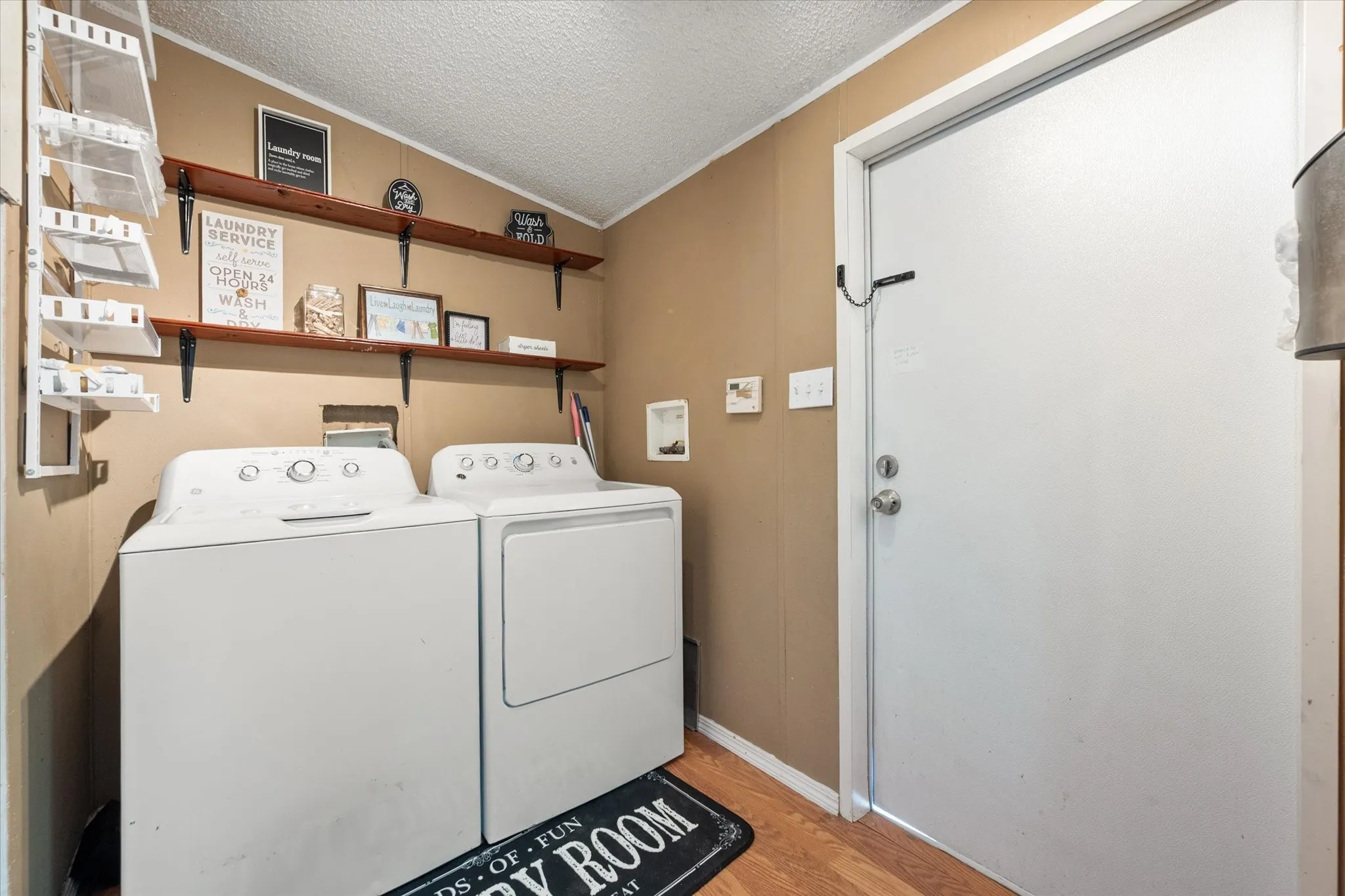 Dedicated laundry area featuring wood-finish flooring