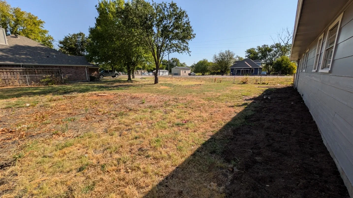 Siding exterior with multiple windows, complemented by a spacious yard with established trees