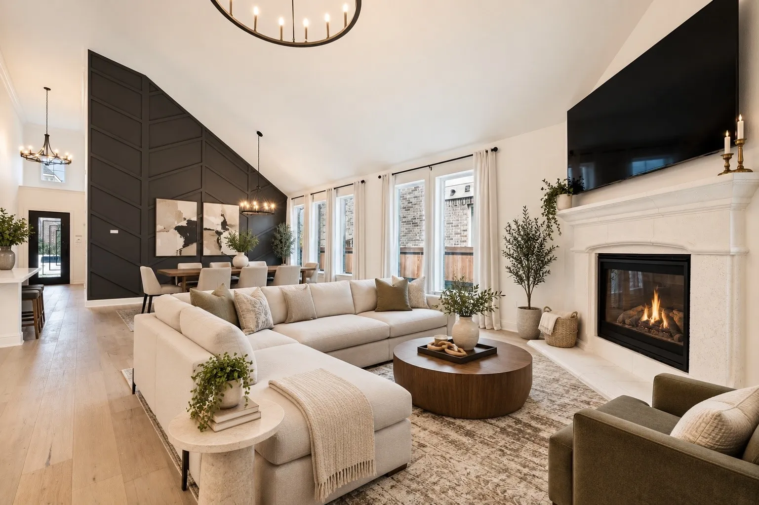 Staged Vaulted ceiling, decorative accent wall, built-in fireplace with mantel, wood-finish flooring, and multiple windows