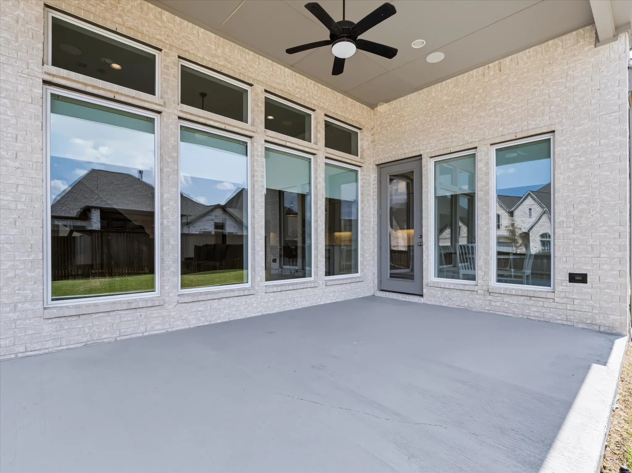 Covered patio with a ceiling fan, recessed lighting, and brick exterior