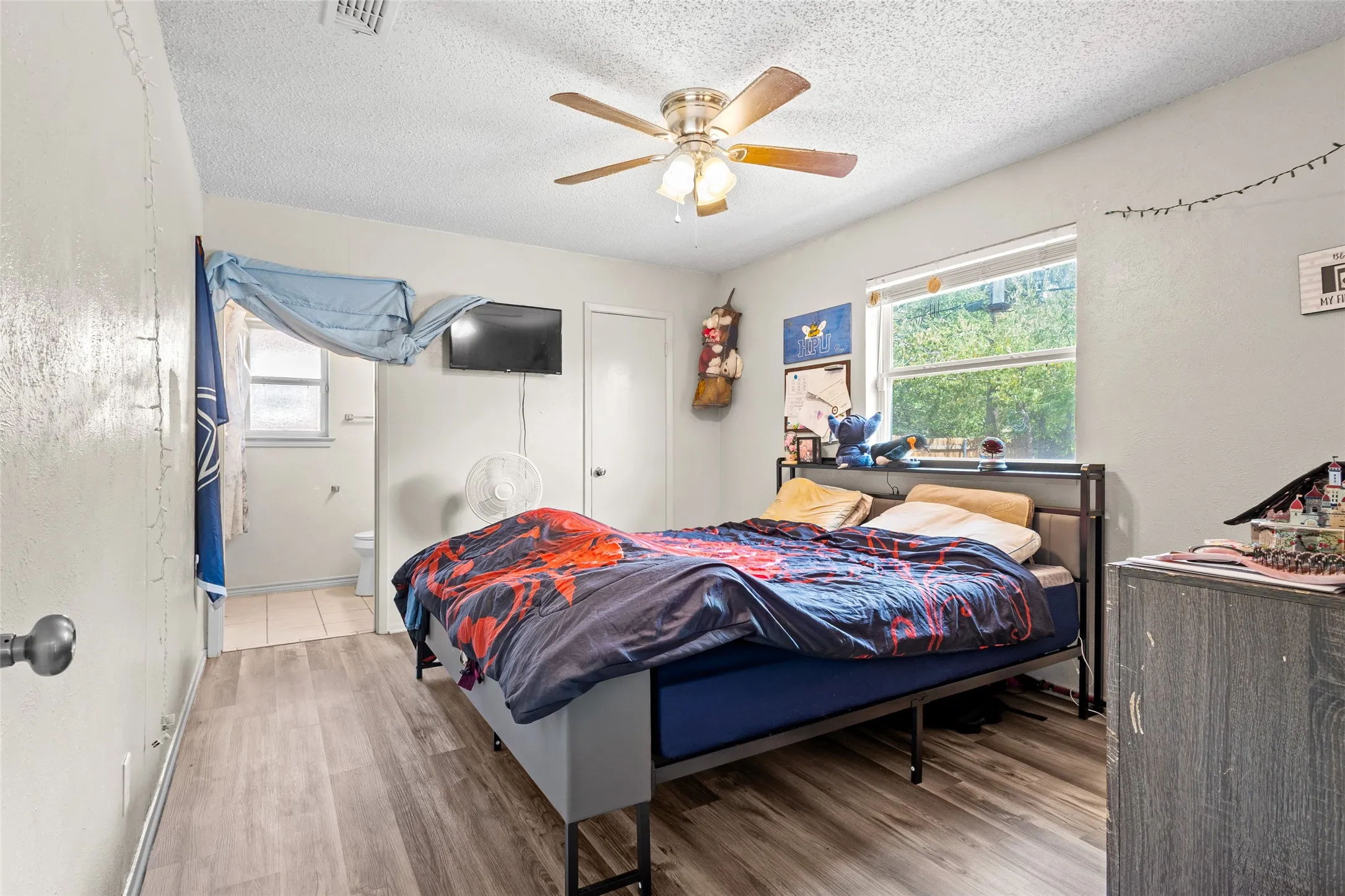 Wood-finish flooring throughout, with a ceiling fan featuring a light kit