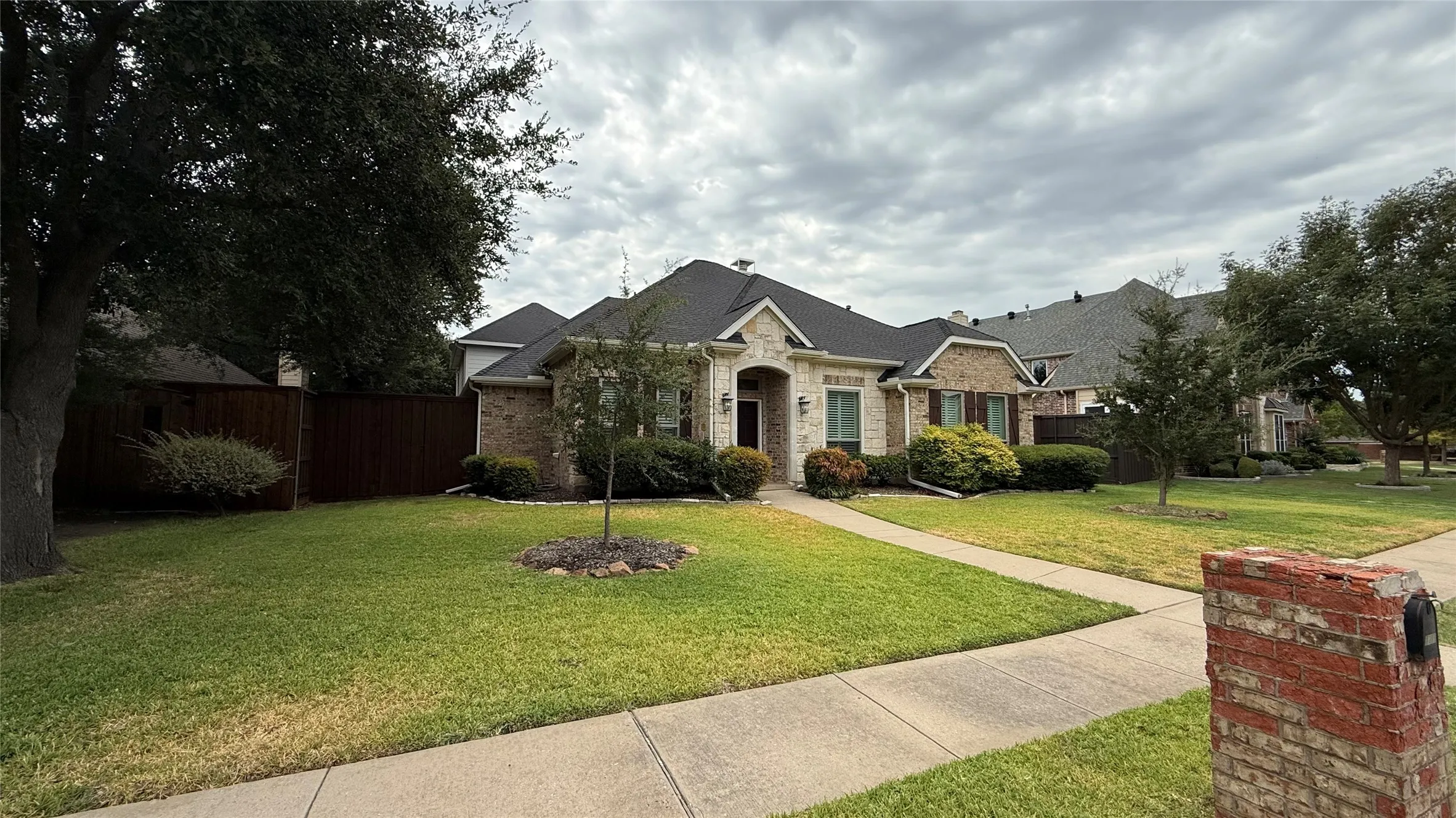 Brick and stone exterior with dark roofing