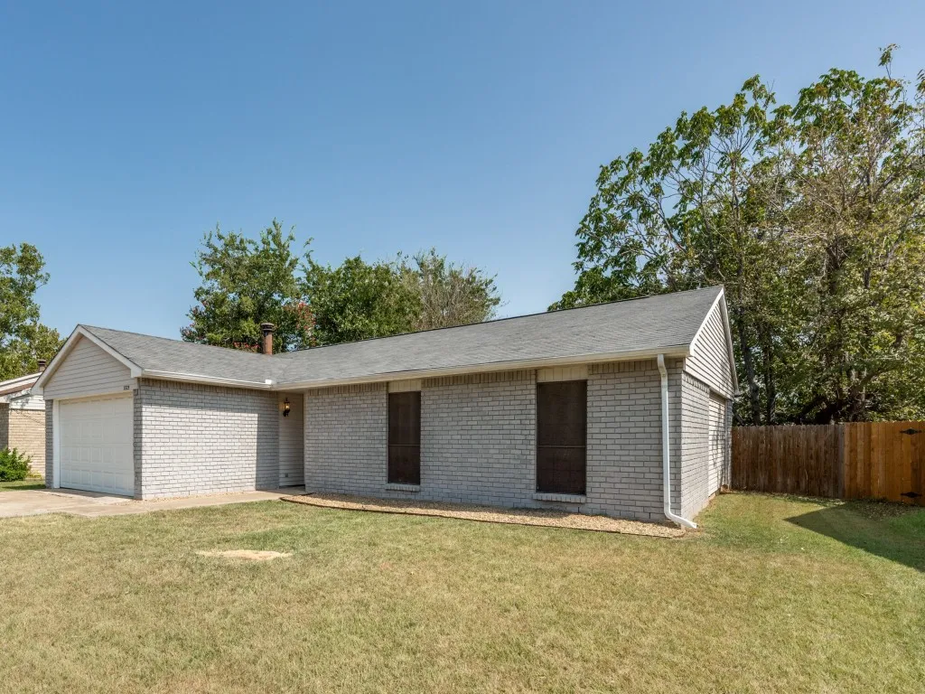 Brick exterior with siding accents, attached garage, and a fenced yard