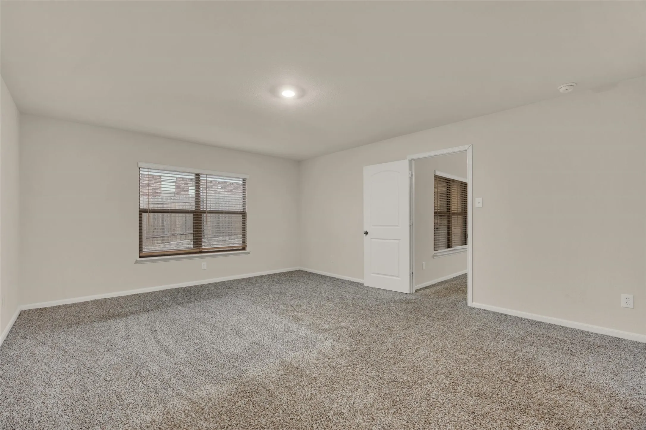Neutral-toned walls complement the grey carpet flooring