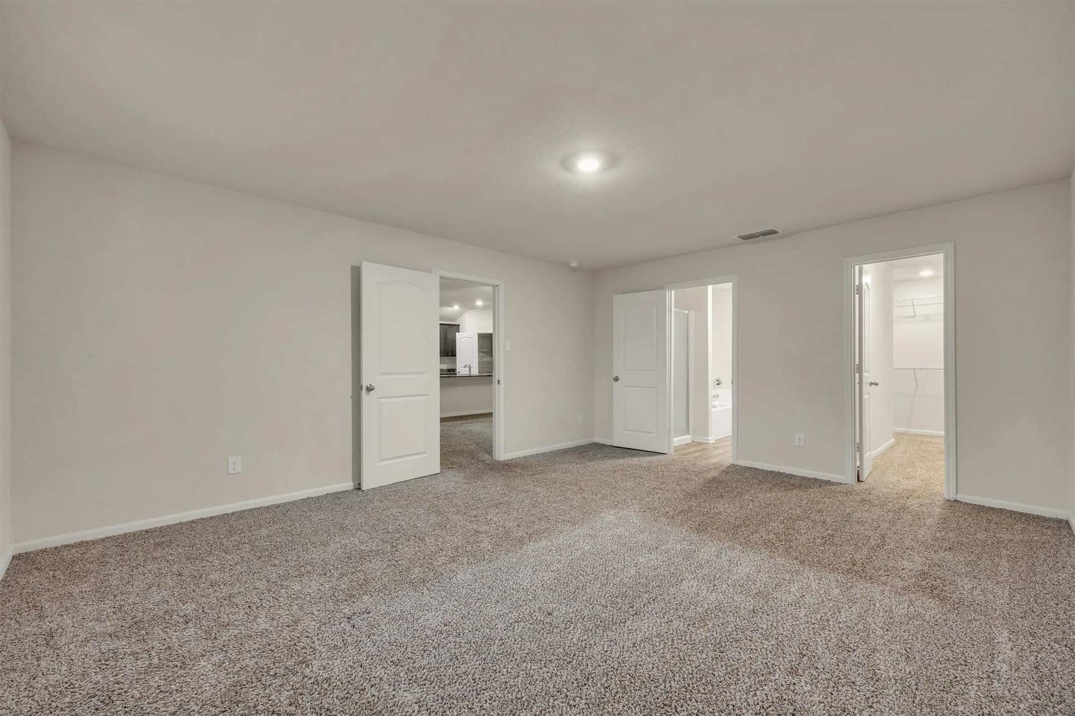 Spacious room with neutral wall tones and carpet flooring