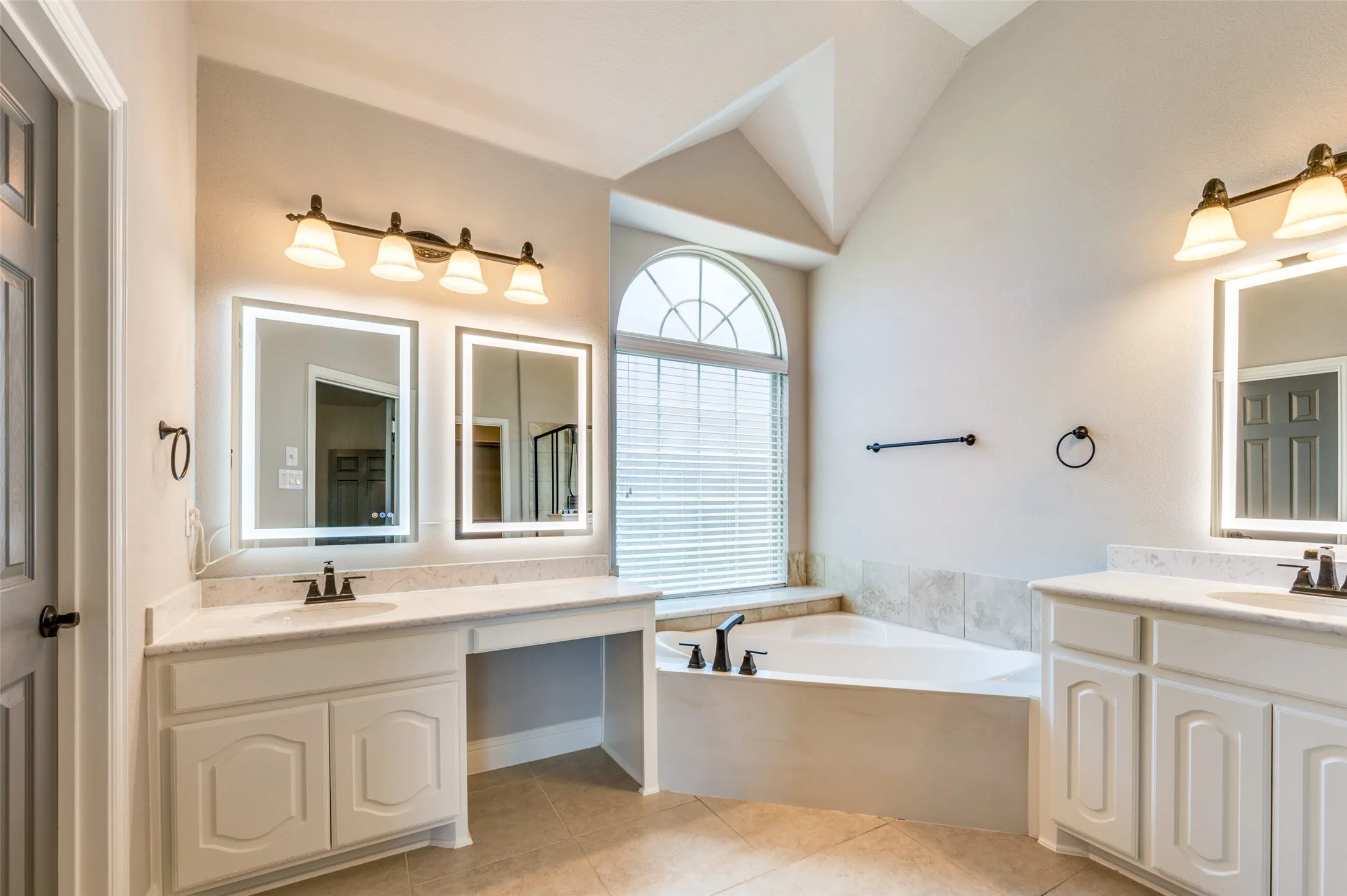 Dual vanity with integrated sinks, quartz countertops, and lighted mirrors