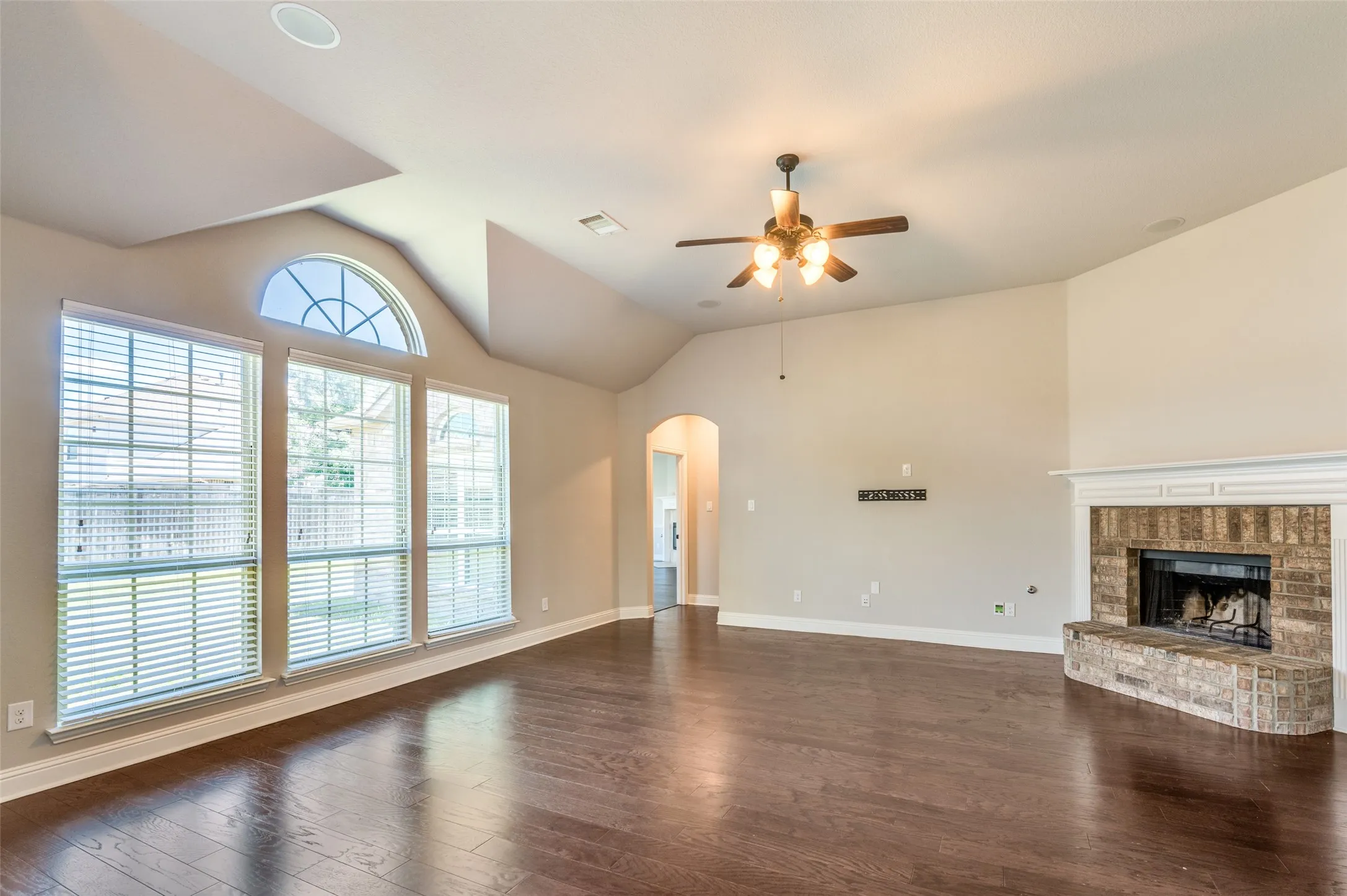 Vaulted ceilings feature a ceiling fan, recessed lighting, and wood-finish flooring