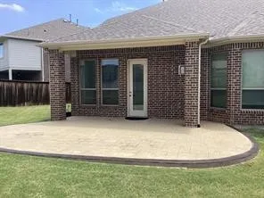 Brick exterior with a covered patio, featuring an accent border, and a glass-paneled door