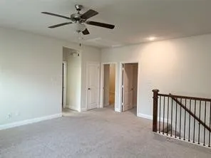 Carpeted flooring, recessed lighting, ceiling fan, and wood newel post with metal balusters