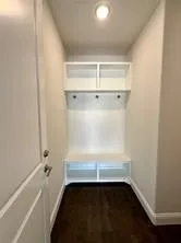 Built-in hall tree with upper shelving, coat hooks, and bench seating with integrated storage