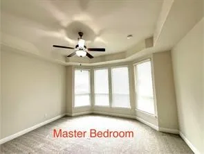 Bay window with multiple panels, ceiling fan with integrated lighting, recessed lighting, and carpeted flooring
