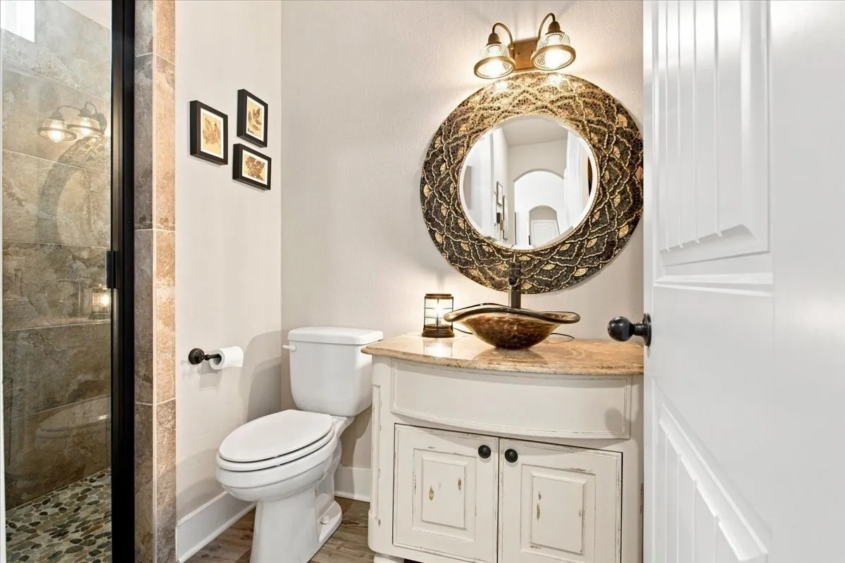 Walk-in shower with natural stone tile and pebble flooring