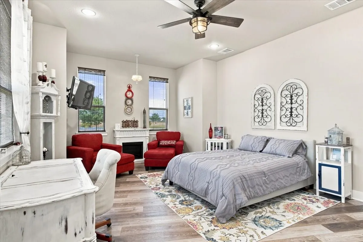 High ceilings, wood-finish flooring, recessed lighting, ceiling fan with integrated light, and multiple windows with blinds