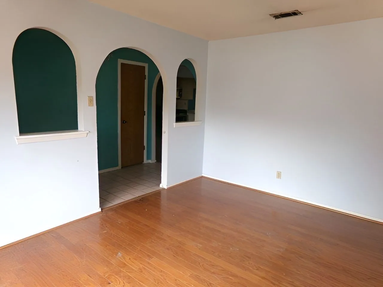 FORMAL Living room-Wood-finish flooring with light-toned walls and arched wall openings