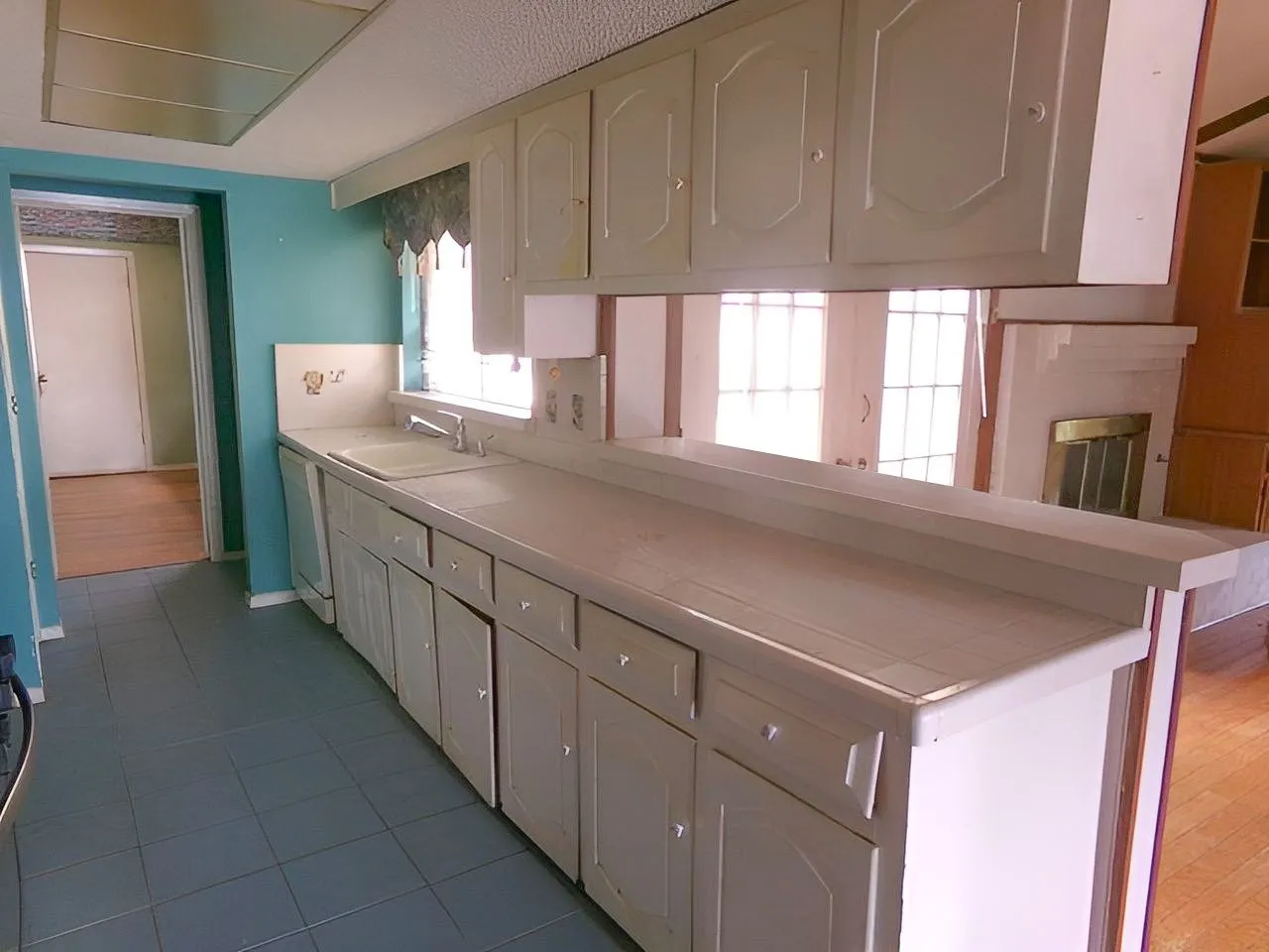 Kitchen with extensive cabinetry, a built-in double basin sink, and tile flooring