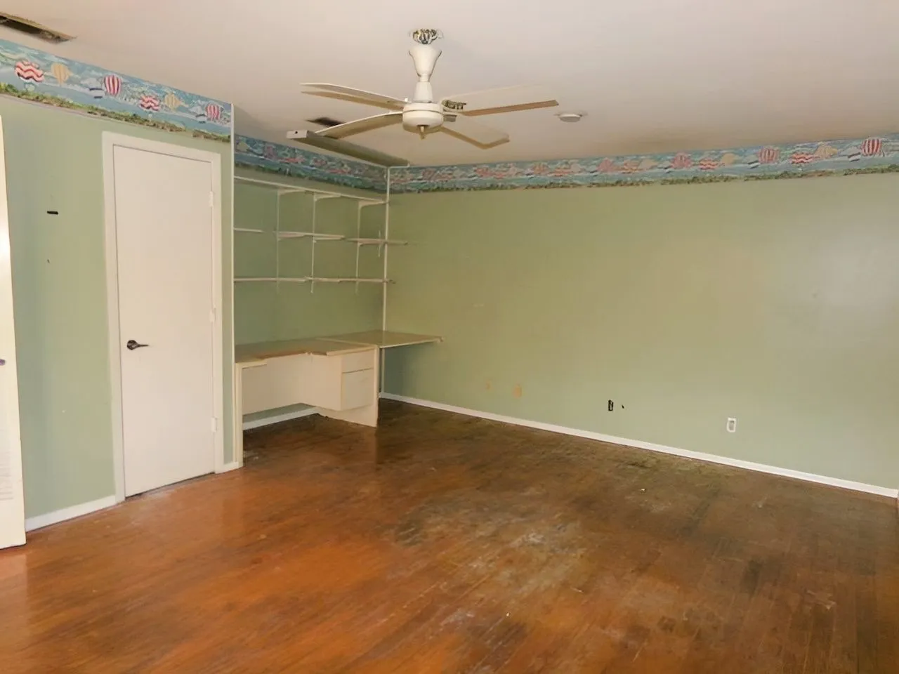 Great 4th bedroom with closet or office with Built-in desk with shelving system, wood-finish flooring, and ceiling fan with integrated lighting
