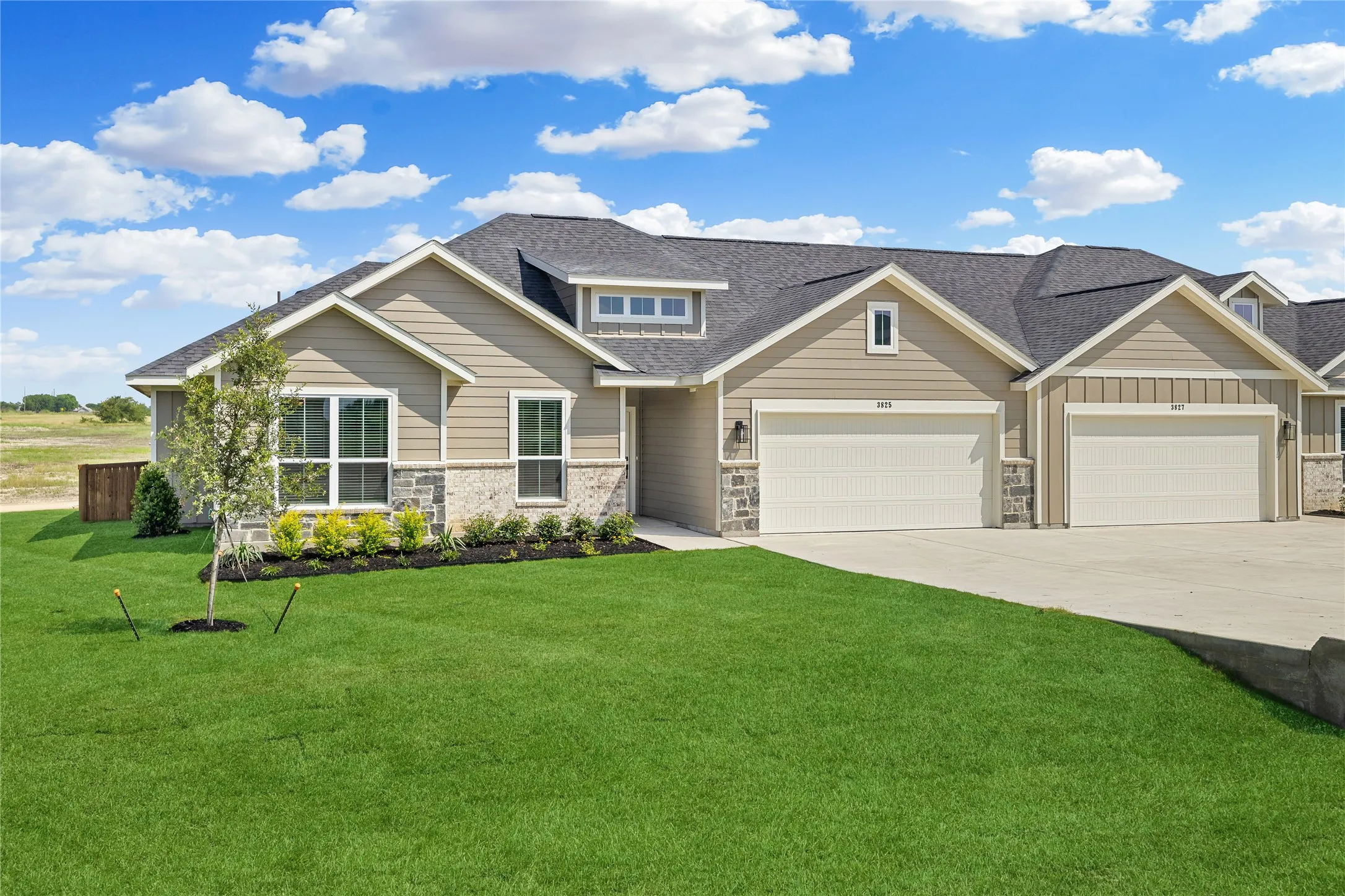 Stone and siding exterior with dark shingle roofing