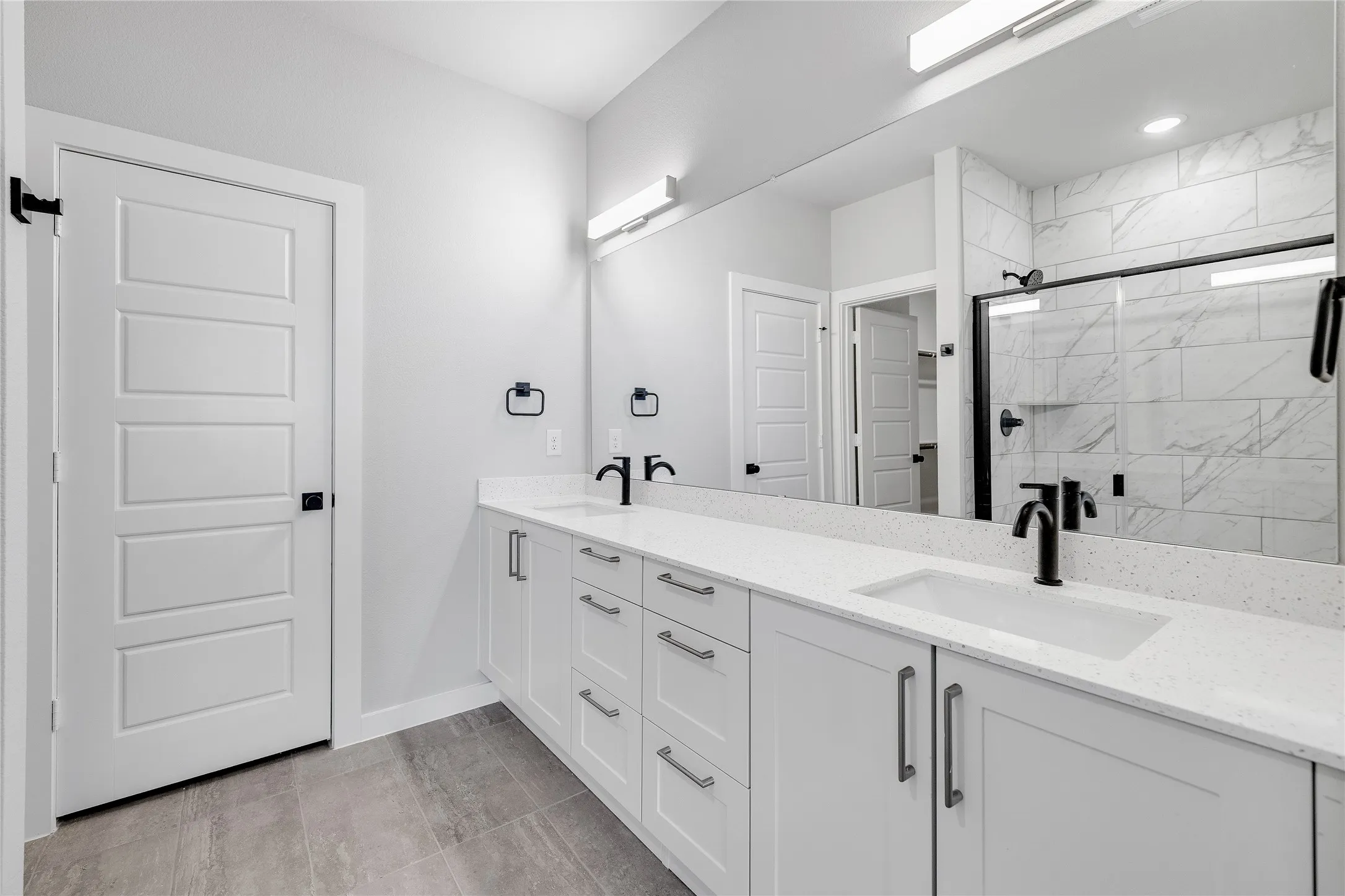Dual vanity with white cabinetry, rectangular undermount sinks, and matte black fixtures