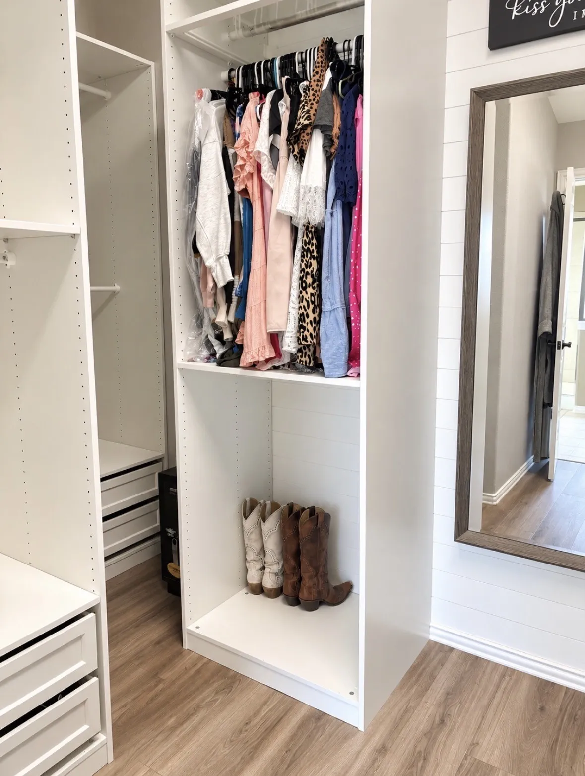 Custom closet system featuring white cabinetry, integrated shelving, and dedicated hanging space