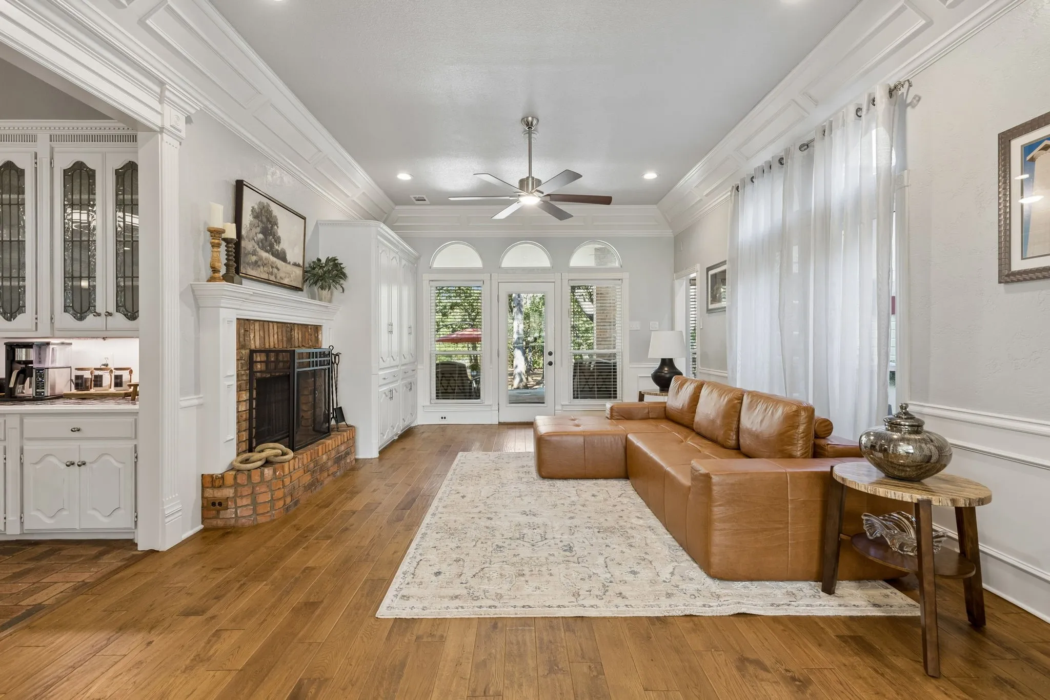 Family room with brick fireplace, built-ins and hardwood floors opens to kitchen, dining room, and outside to the porch and beautiful backyard.