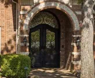 Double wrought-iron doors welcome you home.