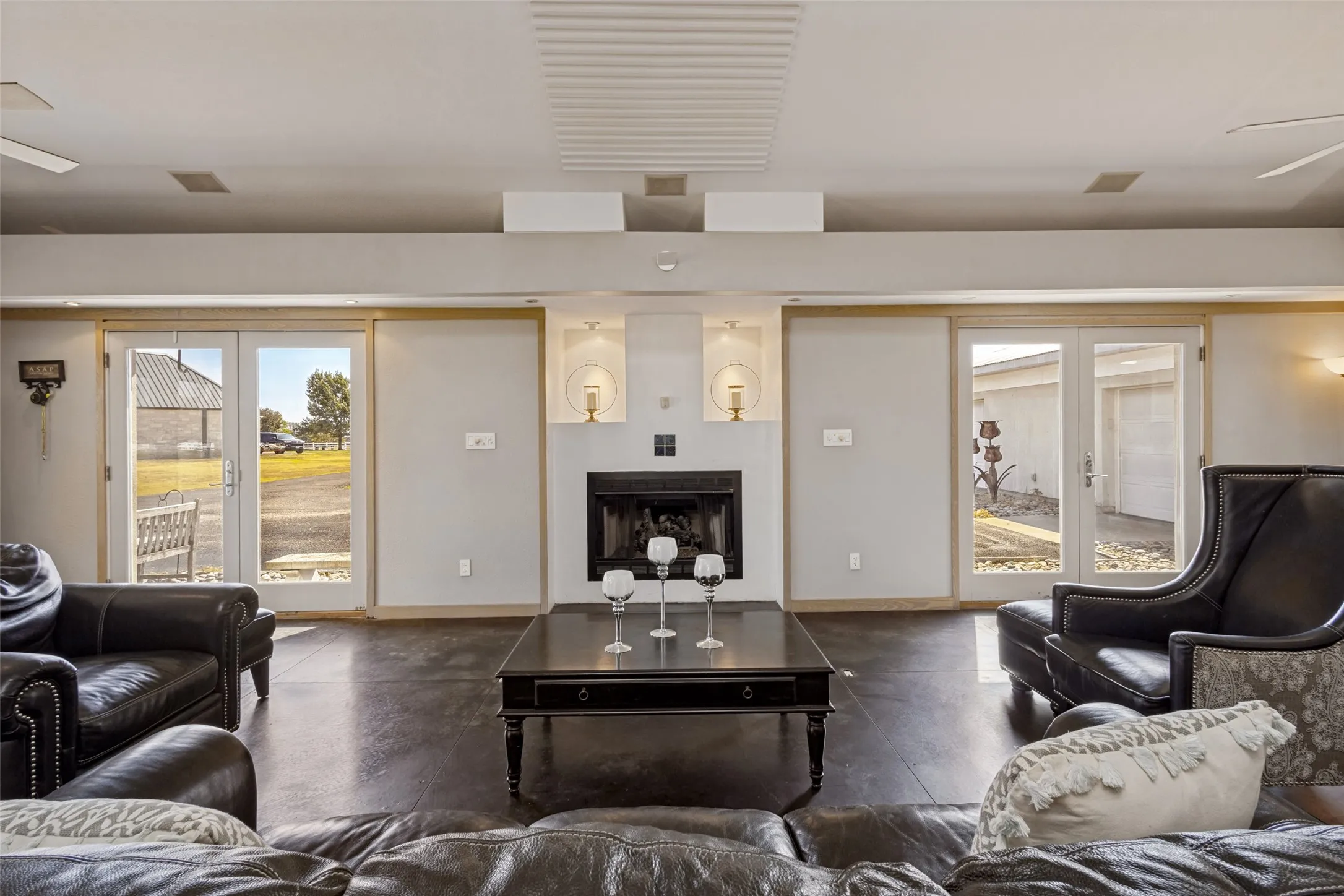 Lit niches on each side of the top of the fireplace add interest and allow a nice spot for decorative items.  French doors flank the fireplace and add additional light to the room.