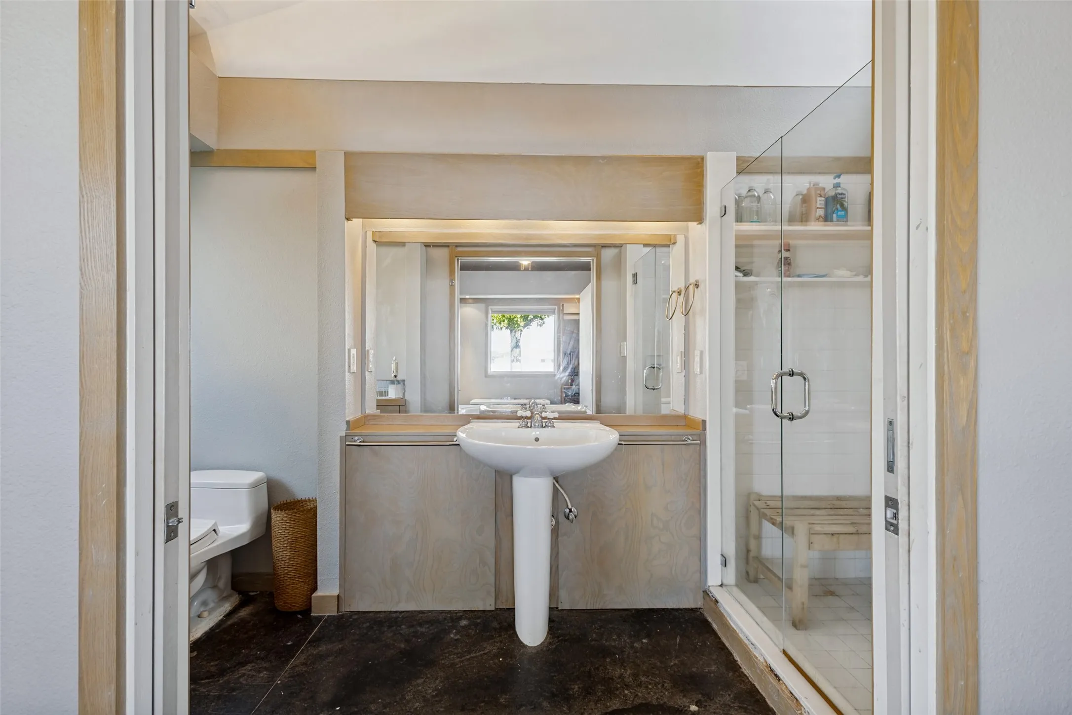 Another section of the bath incudes a pedestal sink with cabinets on either side, a toilet and a shower.  Pocket doors close the area off.