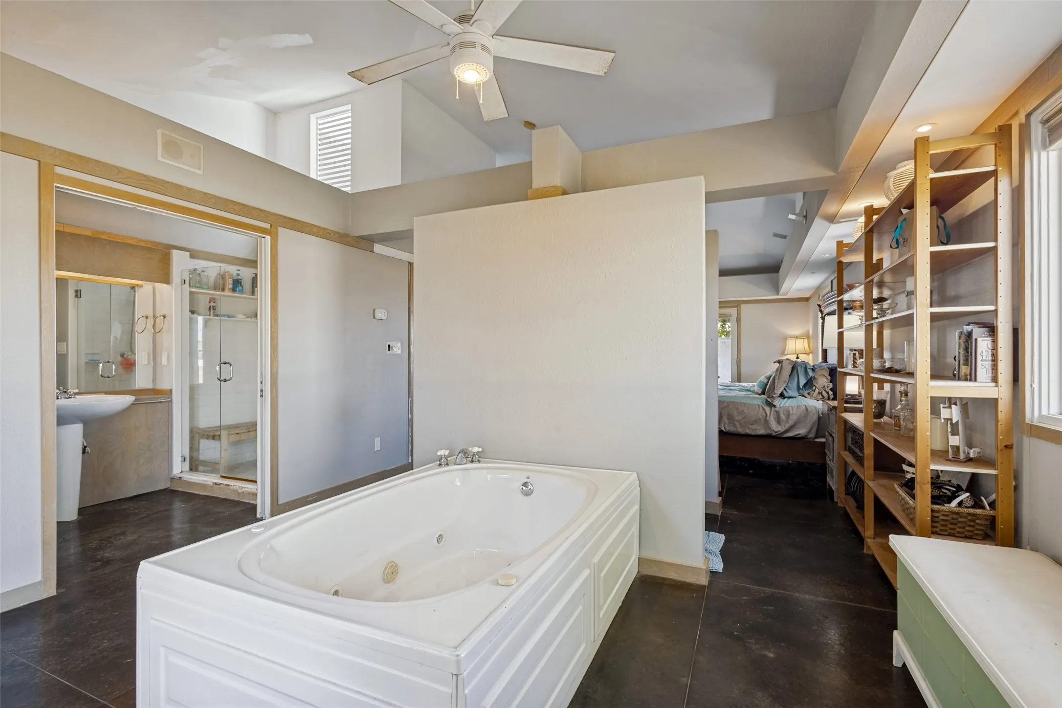 There is a ceiling fan in the primary bath above the jetted tub.  This photo shows how the primary bath is designed in three sections.