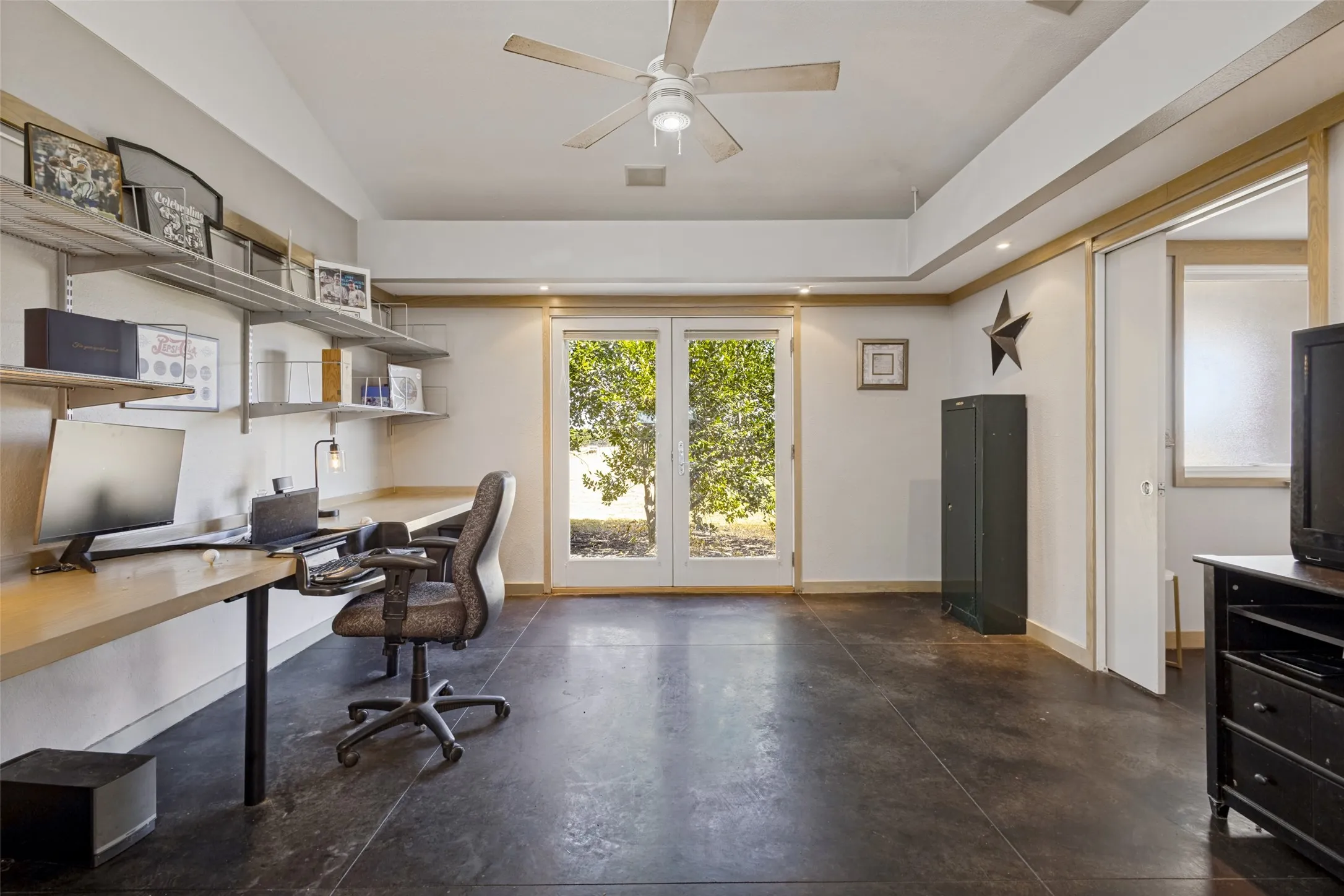 This room is being used as an office with a built-in desk, but with an en-suite bath, it might be better suited to be used as a bedroom.  French doors lead to the side of the home.