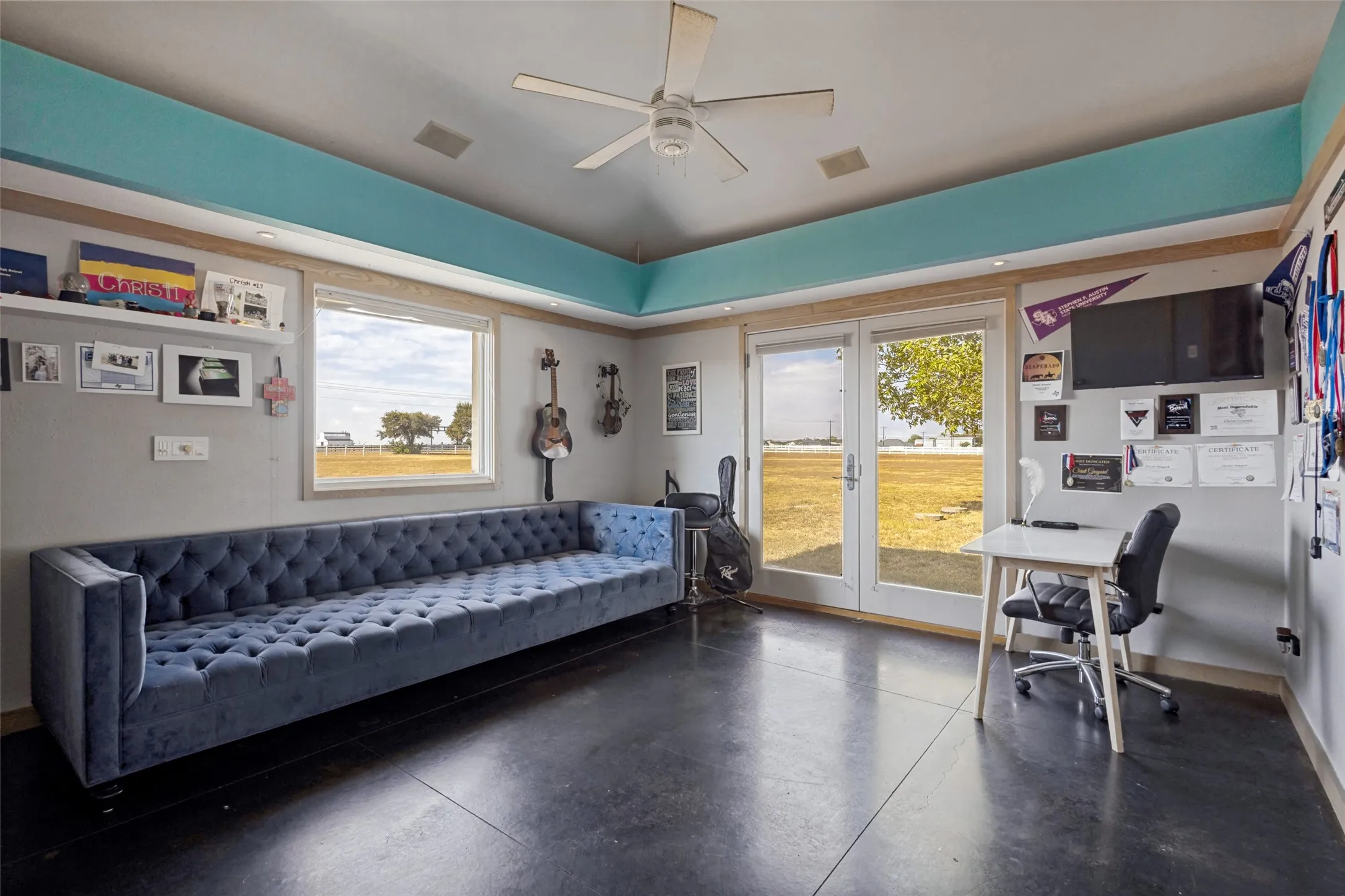 At the end of the second wing, there are two bedrooms with vary similar characteristics.  Each has stained concrete floors and a ceiling fan.  The side of the fur down in this bedroom is painted turquoise.