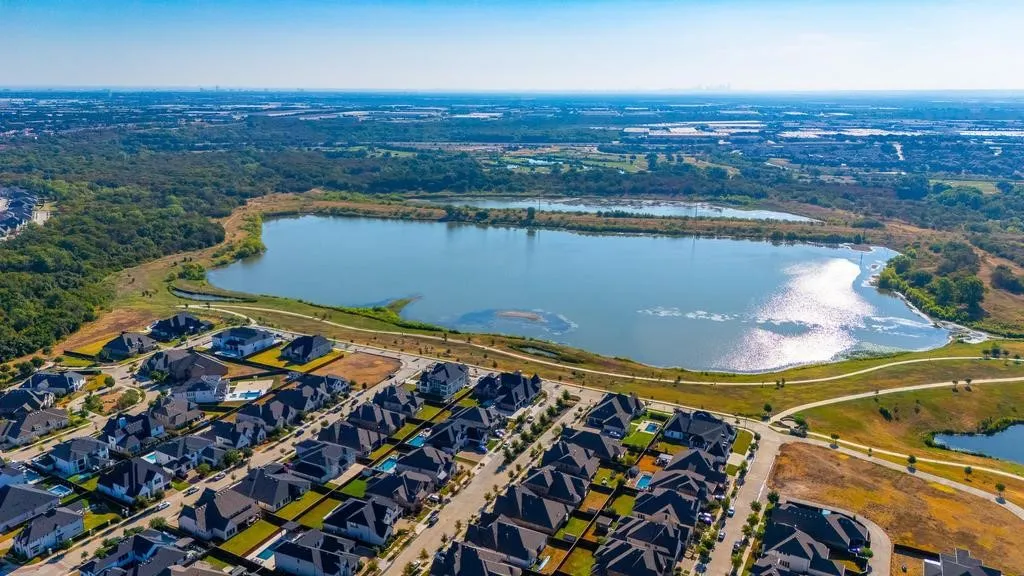 Planned community featuring a large lake, surrounding green spaces, and established residential areas