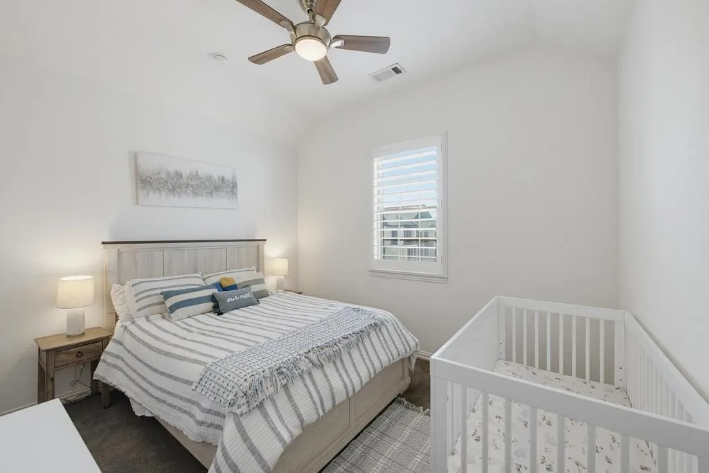 Vaulted ceiling with a ceiling fan, white window shutters, and dark wood-finish flooring