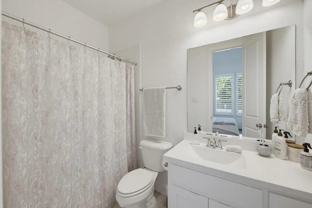 White vanity with an integrated sink, brushed nickel faucet, and a large mirror