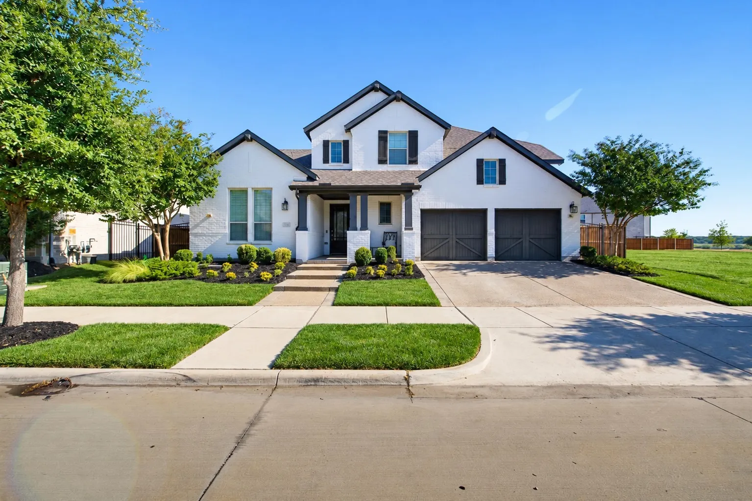 Modern farmhouse exterior with white brick and dark trim accents