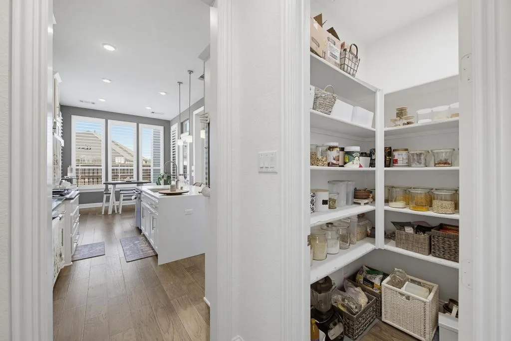 Spacious walk-in pantry with built-in shelving, offering expansive storage
