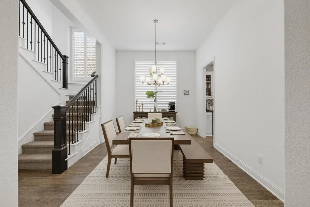Wood-finish flooring with a multi-level staircase featuring dark wood newel posts and black metal balusters